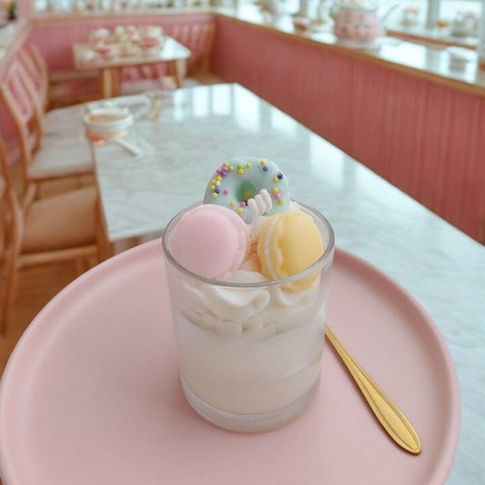 Bougie Gourmande Chantilly en verre, décorée de mini-macarons pastel et d’un donut kawaii, parfum Goji Orange.