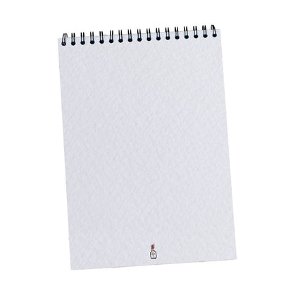Carnet de dessin ouvert, montrant les pages vierges texturées parfaites pour aquarelle et croquis.