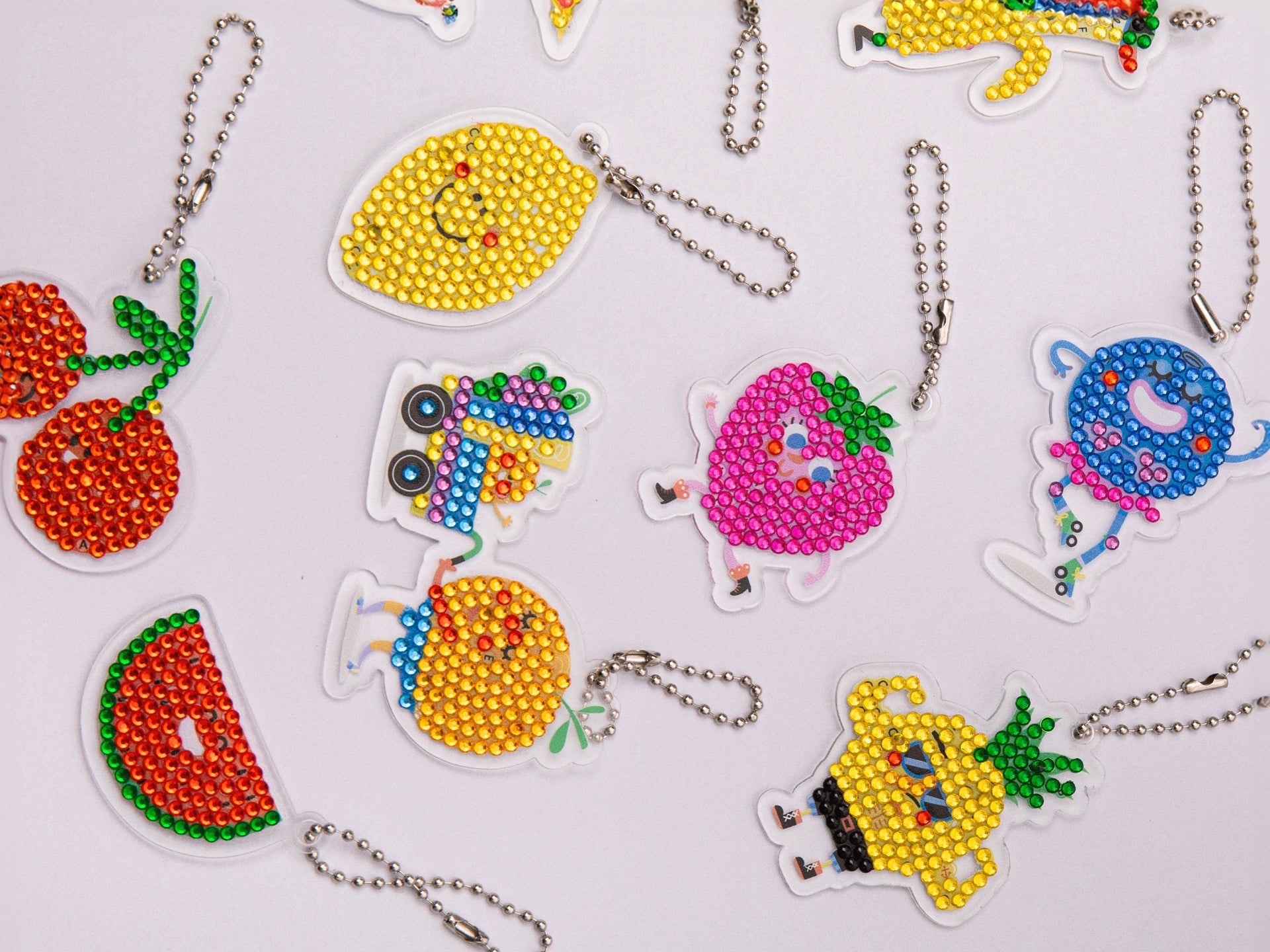 Ensemble de 10 porte-clés fruits terminés, décorés de strass scintillants.